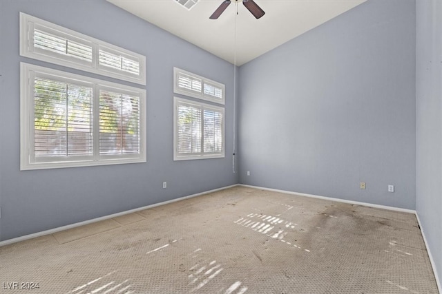 spare room with ceiling fan, a healthy amount of sunlight, and light carpet