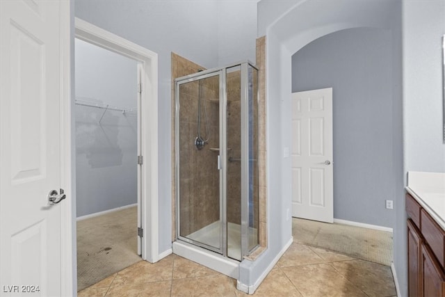 bathroom featuring vanity, walk in shower, and tile patterned flooring