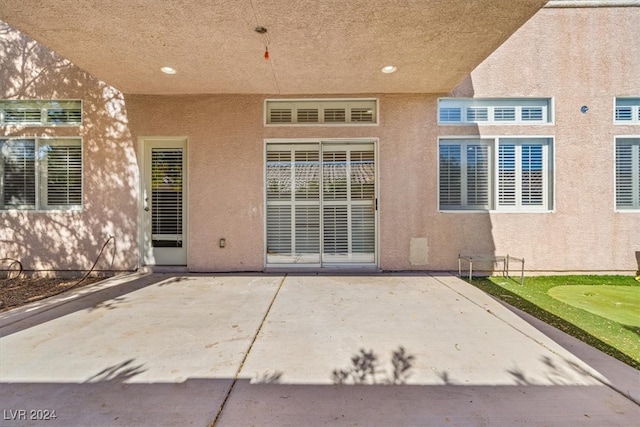 view of exterior entry featuring a patio area