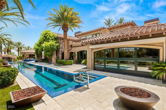 view of swimming pool featuring a patio and an outdoor fire pit