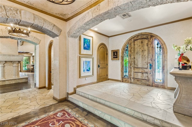 entryway with an inviting chandelier, wood-type flooring, and ornamental molding