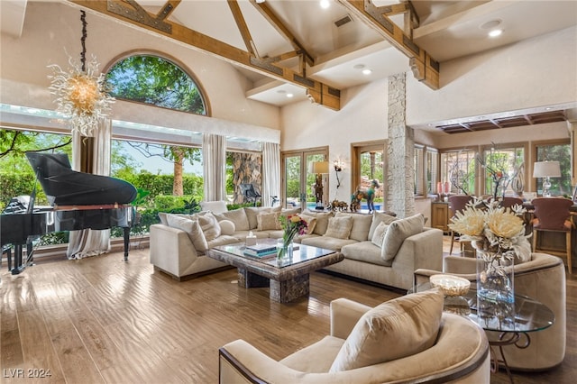 living room featuring high vaulted ceiling, an inviting chandelier, hardwood / wood-style flooring, and beam ceiling