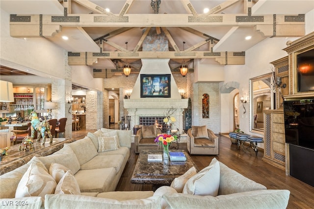 living room featuring dark wood-type flooring, bar area, beam ceiling, and high vaulted ceiling