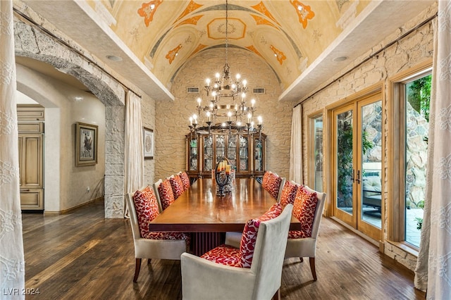 dining area with high vaulted ceiling, an inviting chandelier, dark hardwood / wood-style floors, and french doors