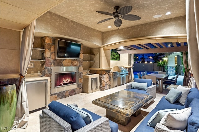 view of patio with ceiling fan, area for grilling, sink, and an outdoor stone fireplace