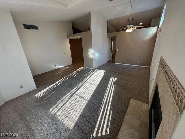 3218 Ocotillo Dr, Laughlin, NV 89029 - unfurnished living room with vaulted ceiling, ceiling fan, a fireplace, and carpet floors