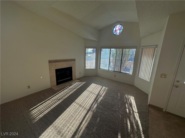 unfurnished living room with a tile fireplace, lofted ceiling, and a textured ceiling