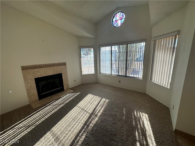 unfurnished living room featuring a fireplace, carpet, a textured ceiling, and a wealth of natural light