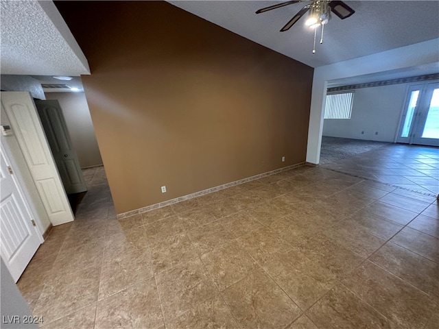 tiled empty room featuring ceiling fan and a textured ceiling