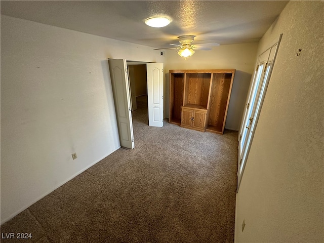 unfurnished bedroom featuring ceiling fan, a closet, carpet, and a textured ceiling