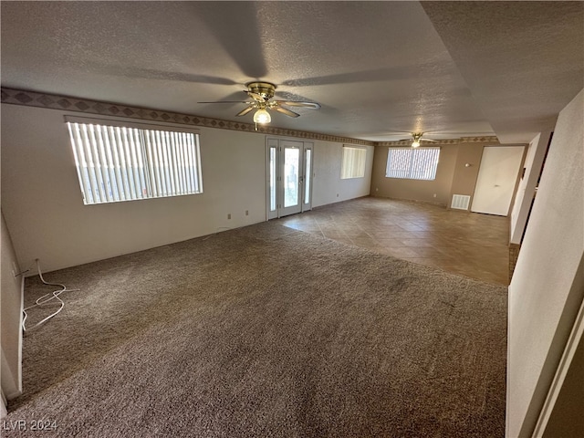 carpeted empty room with a textured ceiling and ceiling fan