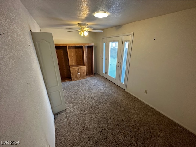 spare room featuring ceiling fan, carpet floors, and a textured ceiling