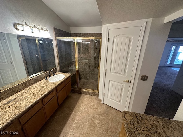 bathroom featuring tile patterned floors, a textured ceiling, vanity, vaulted ceiling, and a shower with shower door