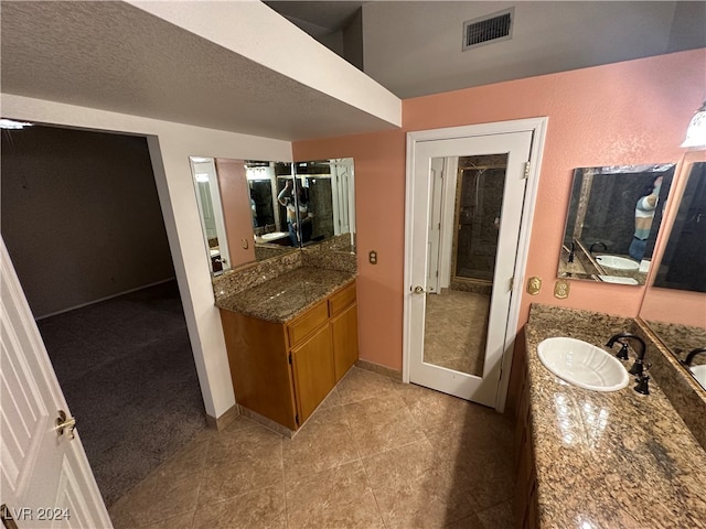 bathroom featuring tile patterned flooring, a textured ceiling, and vanity