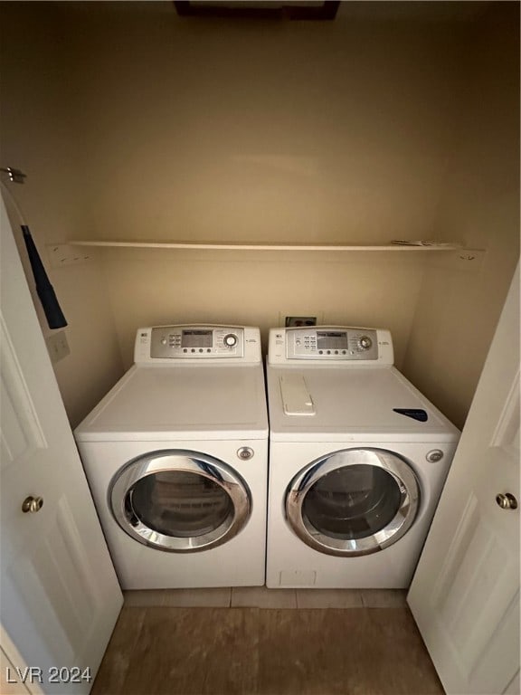 laundry area featuring washing machine and dryer and dark tile patterned floors