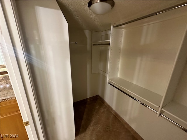 walk in closet with dark tile patterned floors