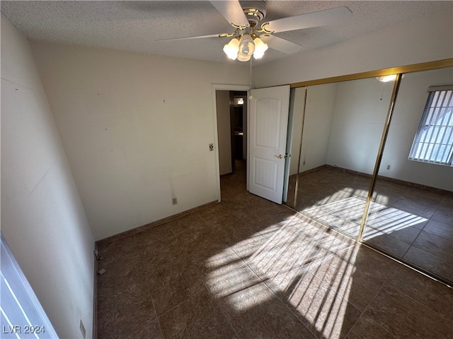 unfurnished bedroom with ceiling fan, a closet, and a textured ceiling