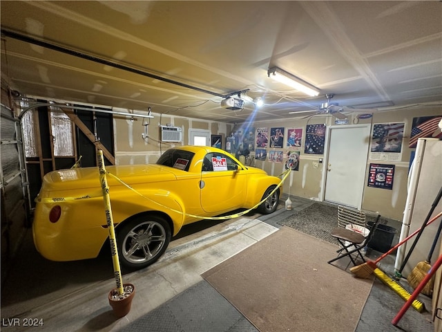 garage featuring a garage door opener, ceiling fan, and a wall unit AC