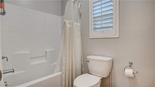 bathroom featuring shower / tub combo with curtain and toilet