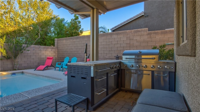 view of patio featuring a fenced in pool, a grill, and an outdoor kitchen