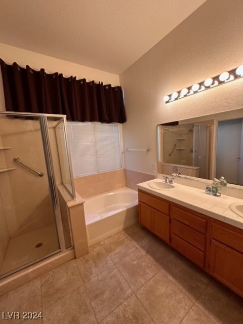 bathroom with tile patterned flooring, vanity, and separate shower and tub