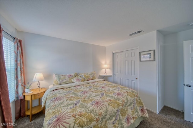 carpeted bedroom featuring a closet and visible vents