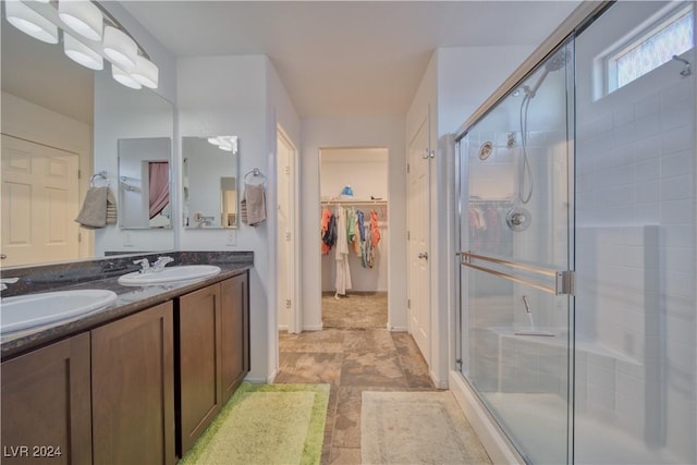 full bath featuring a stall shower, a spacious closet, and a sink