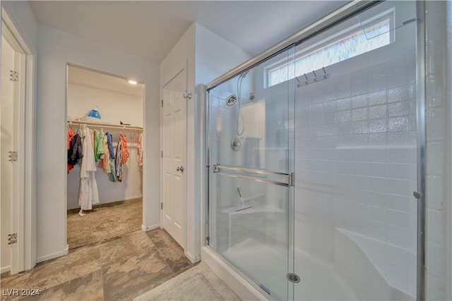 bathroom featuring a spacious closet and a stall shower