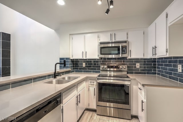 kitchen with white cabinets, light wood-type flooring, sink, and appliances with stainless steel finishes