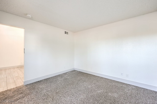 spare room featuring a textured ceiling and hardwood / wood-style flooring