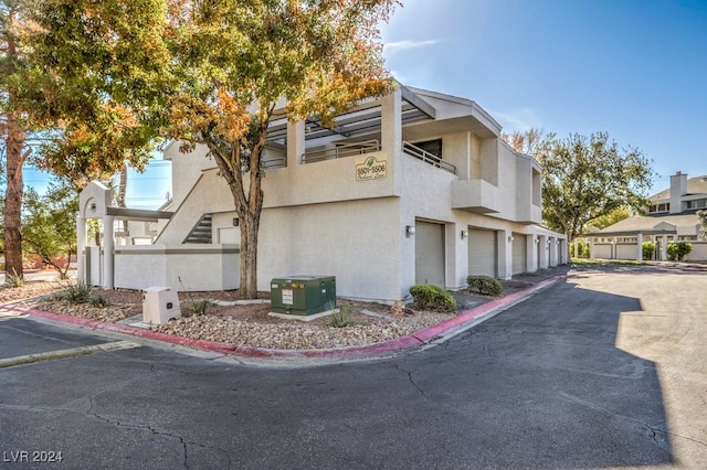 view of home's exterior with a garage, a balcony, and central AC