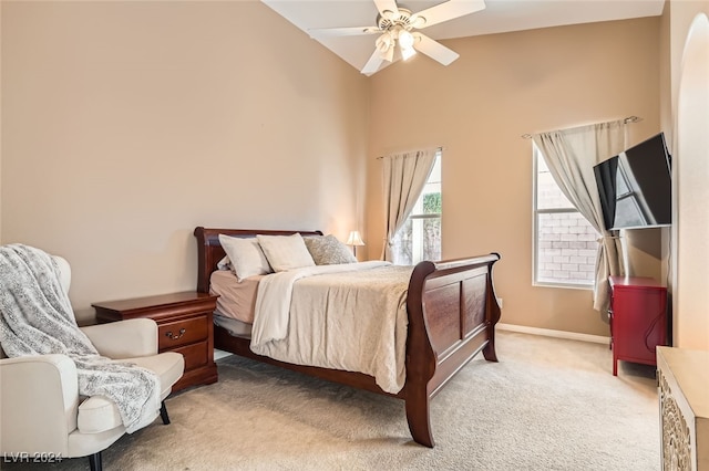 carpeted bedroom with ceiling fan and high vaulted ceiling