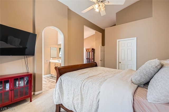 bedroom featuring high vaulted ceiling, light colored carpet, ensuite bath, and ceiling fan