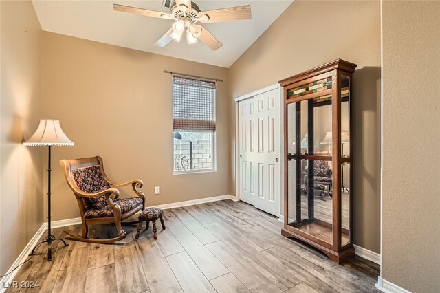 living area with ceiling fan, lofted ceiling, and hardwood / wood-style flooring