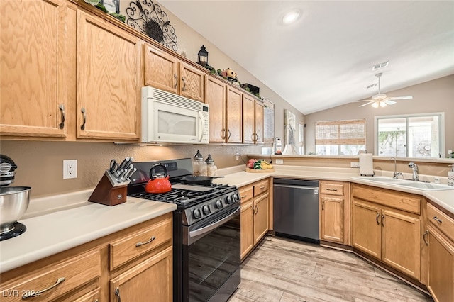 kitchen featuring gas stove, ceiling fan, dishwasher, light hardwood / wood-style floors, and vaulted ceiling