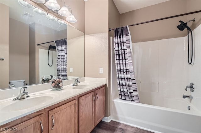 full bathroom featuring shower / bath combo with shower curtain, vanity, hardwood / wood-style floors, and toilet