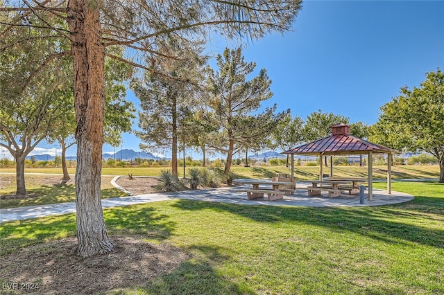 view of property's community with a mountain view, a gazebo, and a lawn