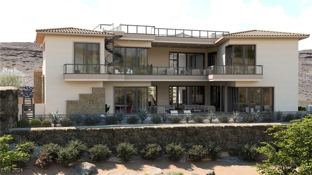 rear view of property with an outdoor living space, a patio, and a balcony