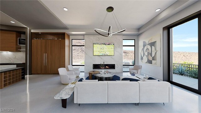 living room featuring a healthy amount of sunlight, a high end fireplace, and an inviting chandelier