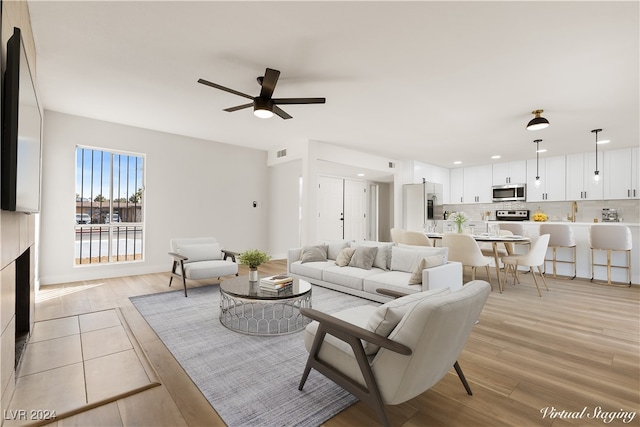 living room featuring ceiling fan and light hardwood / wood-style floors