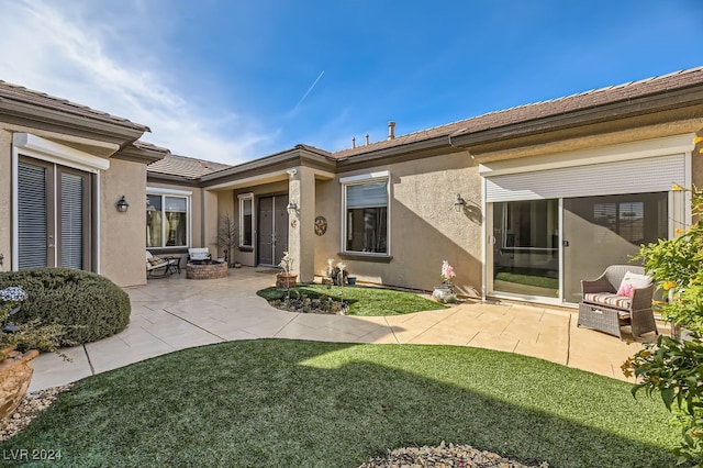 rear view of house featuring a lawn and a patio area