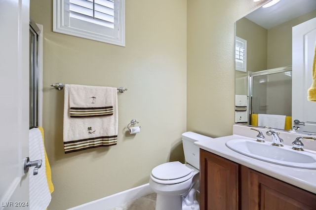 bathroom with tile patterned floors, vanity, toilet, and a shower with door