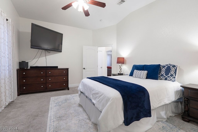 bedroom featuring ceiling fan, light carpet, and vaulted ceiling