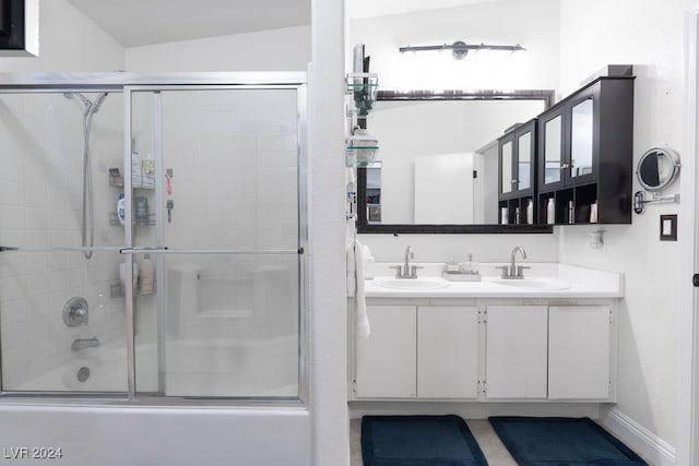 bathroom with vanity, lofted ceiling, and bath / shower combo with glass door