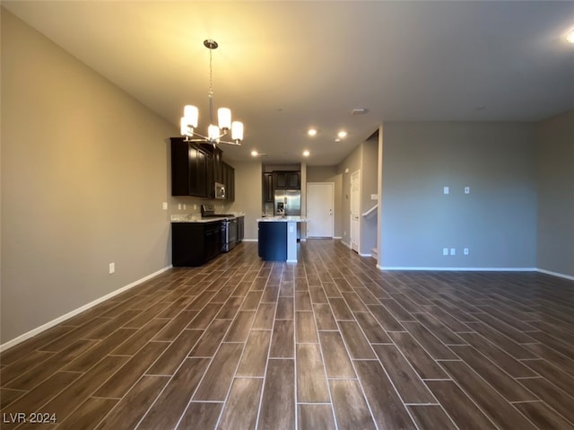 kitchen with dark hardwood / wood-style flooring, a center island, an inviting chandelier, appliances with stainless steel finishes, and decorative light fixtures