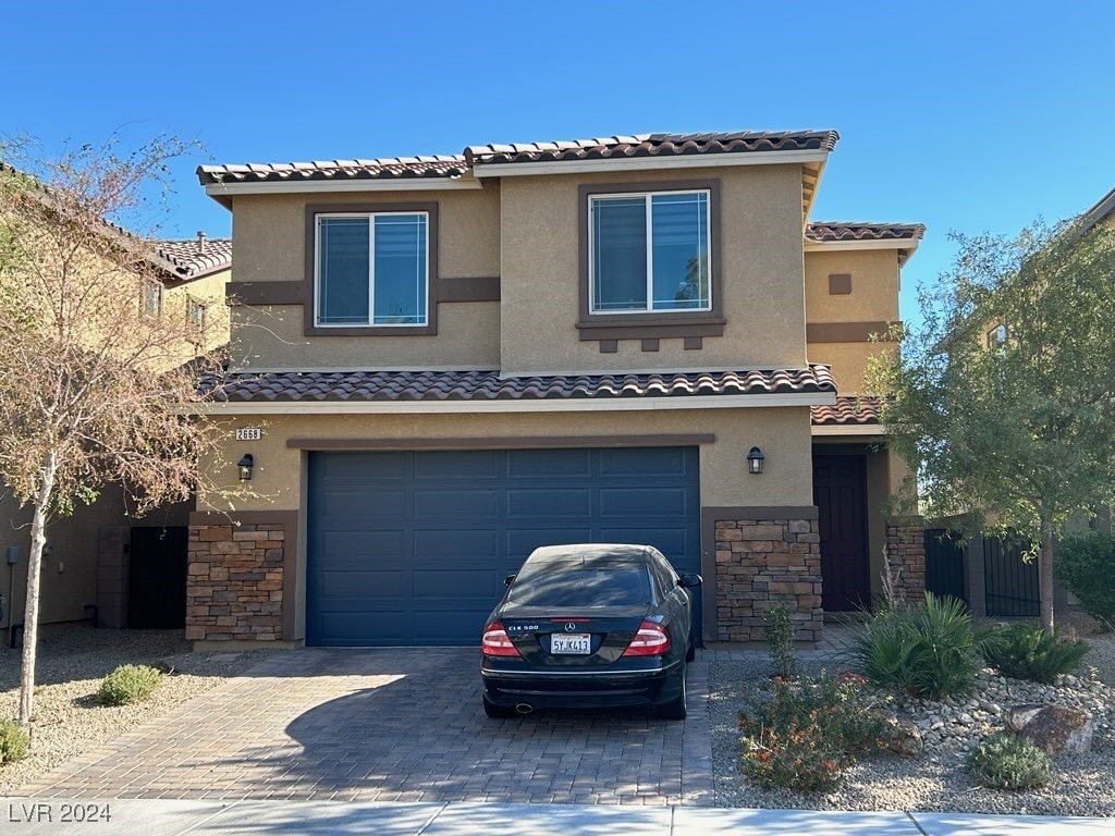 mediterranean / spanish-style house with a garage