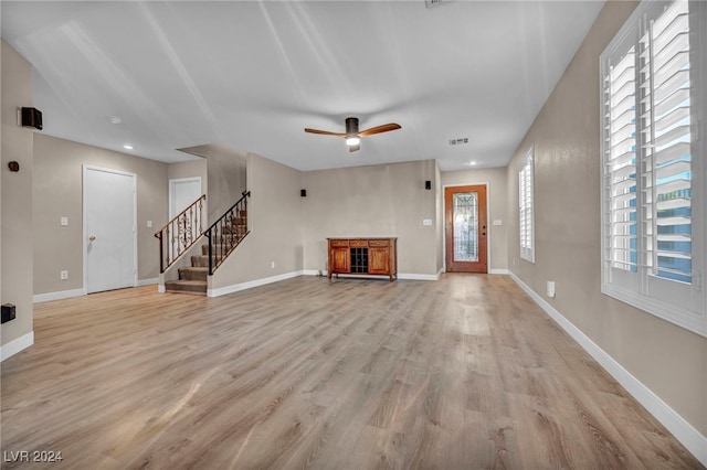 unfurnished living room featuring light hardwood / wood-style flooring and ceiling fan