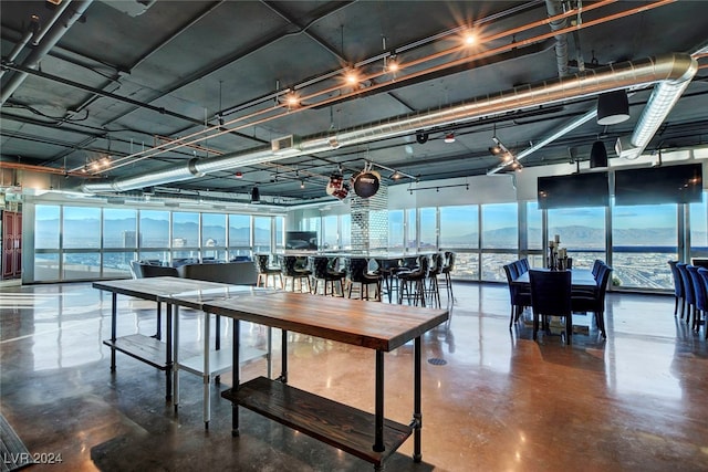 dining room featuring concrete floors, a water view, and a healthy amount of sunlight