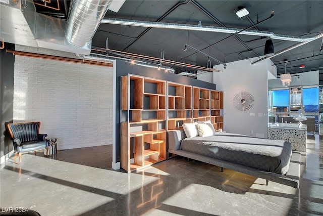 bedroom with concrete floors and brick wall