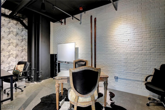 office area with concrete floors and brick wall